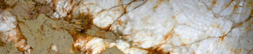 Across a Patagonia slab, polished: white crystal veined in rust over an olive ground